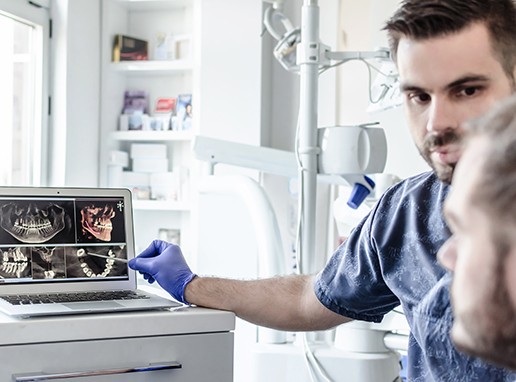 a dentist showing a patient diagnostic scans of their mouth