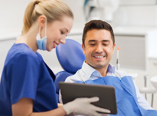 Dental assistant reviewing information with patient on tablet