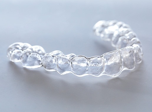 Closeup of clear aligner on grey surface